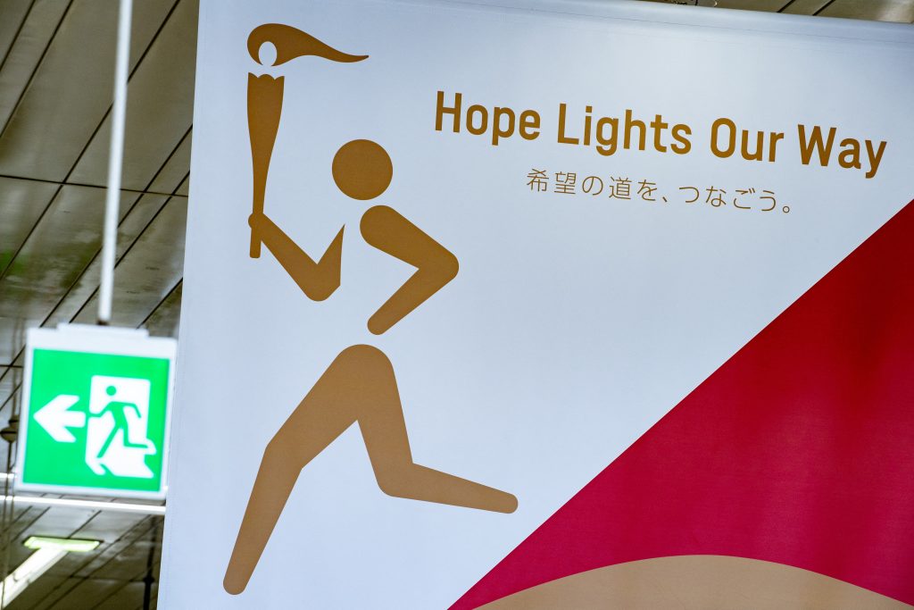 2020年3月24日、福島県の福島駅内に描かれた東京オリンピック2020聖火リレーのポスター（右）。(AFP)