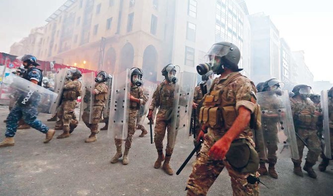 大規模な科学爆発の後、ベイルート中心部の国民議会議事堂付近での昨年8月の抗議集会の最中に、レバノンの治安部隊が集まっている。〔資料/AFP通信〕