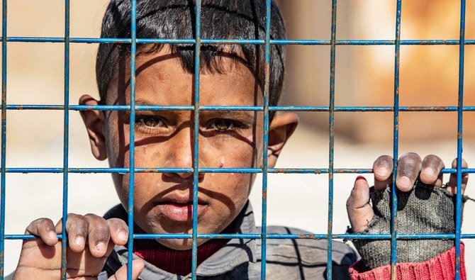 2021年2月20日、シリア北東部ハサカ県で、ダーシュのグループの戦士の親戚と見られるクルド人が運営するアルホルキャンプからシリアの家族の別グループが解放される中、少年が出発を待っている。（AFP）