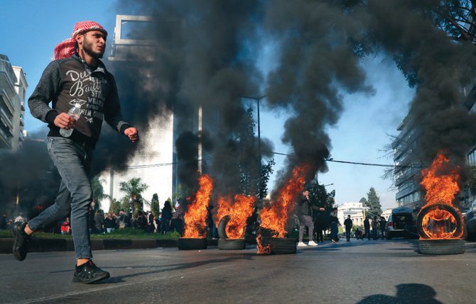 ベイルートで水曜日、拘束されている反政府活動家の解放を求めるデモ中、タイヤを燃やして道路を塞ぐ抗議者たち。(AP)