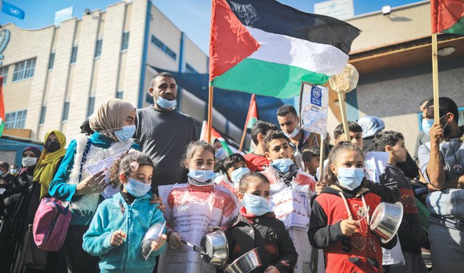 ガザ地区の国連パレスチナ難民救済事業機関の決定は同機関による食料支援削除であるとする抗議活動に、パレスチナ人の子供たちも参加する。（資料/AFP）