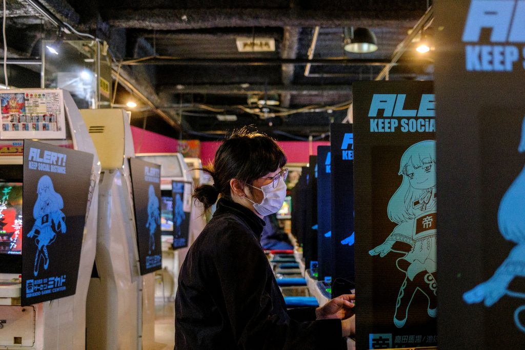 2021年1月26日に撮影されたこの写真は、東京の新宿区にあるゲームセンター「ミカド」で、1人の女性がゲームをプレイしているところを写している。（AFP）