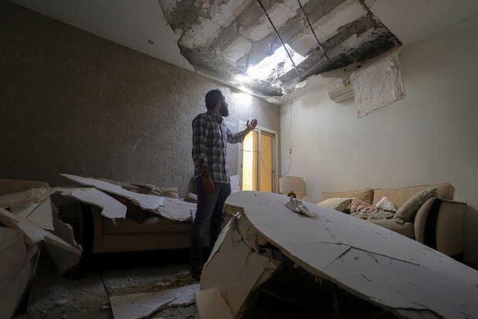 サウジのリヤドで、フーシ派のミサイル攻撃に巻き込まれ、迎撃されたミサイルの残骸で被害を受けた自宅の被害状況を検査するモハメド・ファヒム、2021年2月28日。 (ロイター)