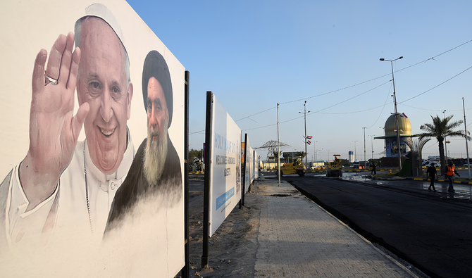 2021年3月3日、イラクのナジャフで、予定されているローマ教皇のイラク訪問の前に、通りでフランシスコ教皇とイラクのシーア派最高権威アリ・シスタニ師のポスターが見られる。（ロイター）