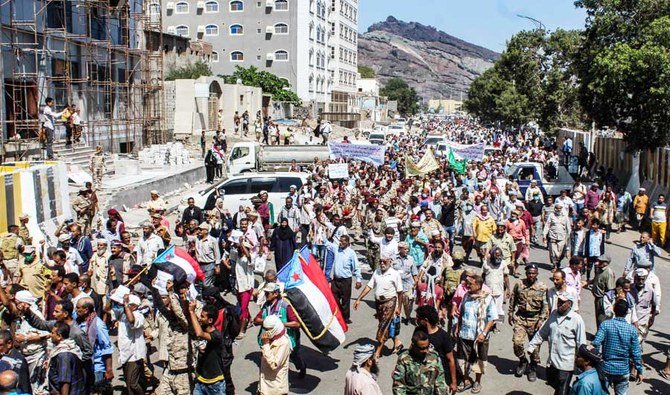 2021年3月16日、南の港湾都市アデンのクレーター地区にある国際的に承認されたイエメン政府の本部、アルマーシク宮殿の外に集まるデモ参加者。南イエメンの旧旗を掲げる者もいる。(AFP)