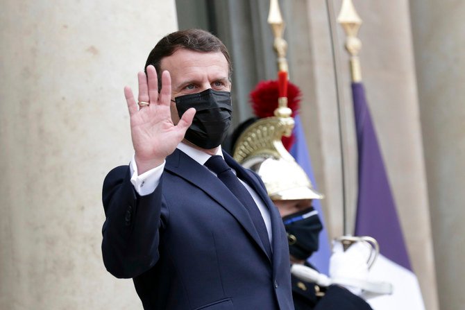 2021年3月18日（木）、パリのエリゼ宮で記者団に向かって手を挙げるフランスのエマニュエル・マクロン大統領。（AP通信）
