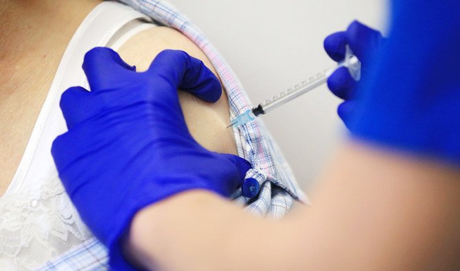 写真は、ファイザー社・ビオンテック社製の新型コロナウイルス感染症ワクチンを患者に投与する看護師。（AFP通信）