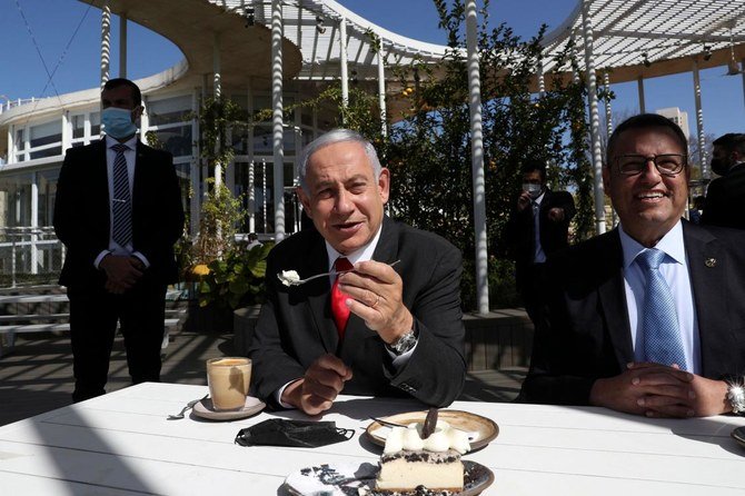 イスラエルがロックダウンの緩和に向け一歩を踏み出す中、新たに再開したエルサレムのレストランを訪れるイスラエルのベンヤミン・ネタニヤフ首相（左）。2021年3月7日。（AFP）