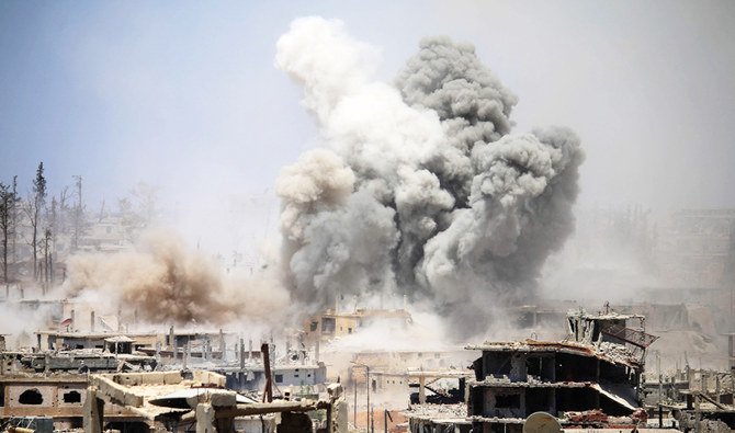 2017年5月22日撮影の資料写真。シリア南部の都市ダルアーの反政府地域への空爆が報告された後、建物から煙が上がっている。(AFP)