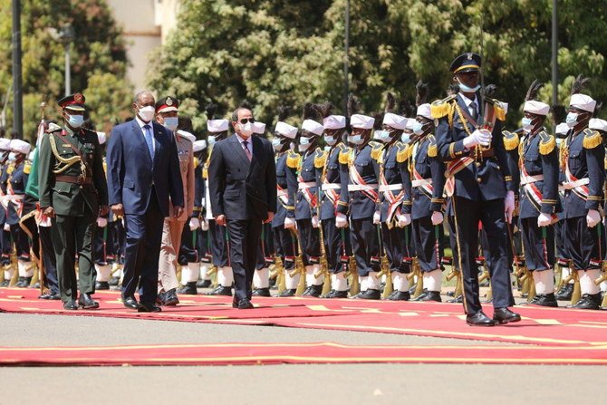 スーダン・ハルツームでの歓迎式典で、主権評議会のアブデル・ファッターハ・ブルハン議長と共に歩むアブドルファッターフ・アッ＝シーシー大統領、2021年3月6日。 (ロイター)