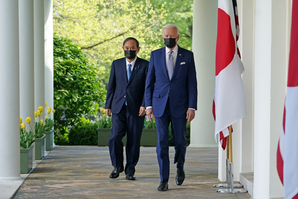 2021年4月16日（金）、ワシントンのホワイトハウスのローズガーデンで開かれる共同記者会見に参加するためにコロネードを通り抜けるジョー・バイデン米大統領と日本の菅義偉首相。（AFP）
