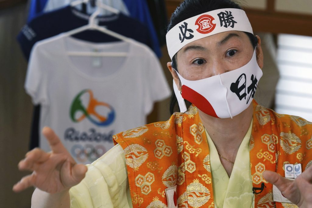 オリンピックファン石川恭子氏が2021年4月10日土曜日、東京の自宅にてインタビューに応じた。石川氏はIT会社の社長で、1992年のバルセロナ大会以来、夏季オリンピックに毎回出席していて、非公式の「国際オリンピック応援団長」として有名になった。彼女はそれぞれのアスリートを応援する各国のファンとかかわることを楽しんでいる。彼女のはちまきとマスクには「必勝」「日本」と書かれている。（AP Photo/Eugene Hoshiko）
