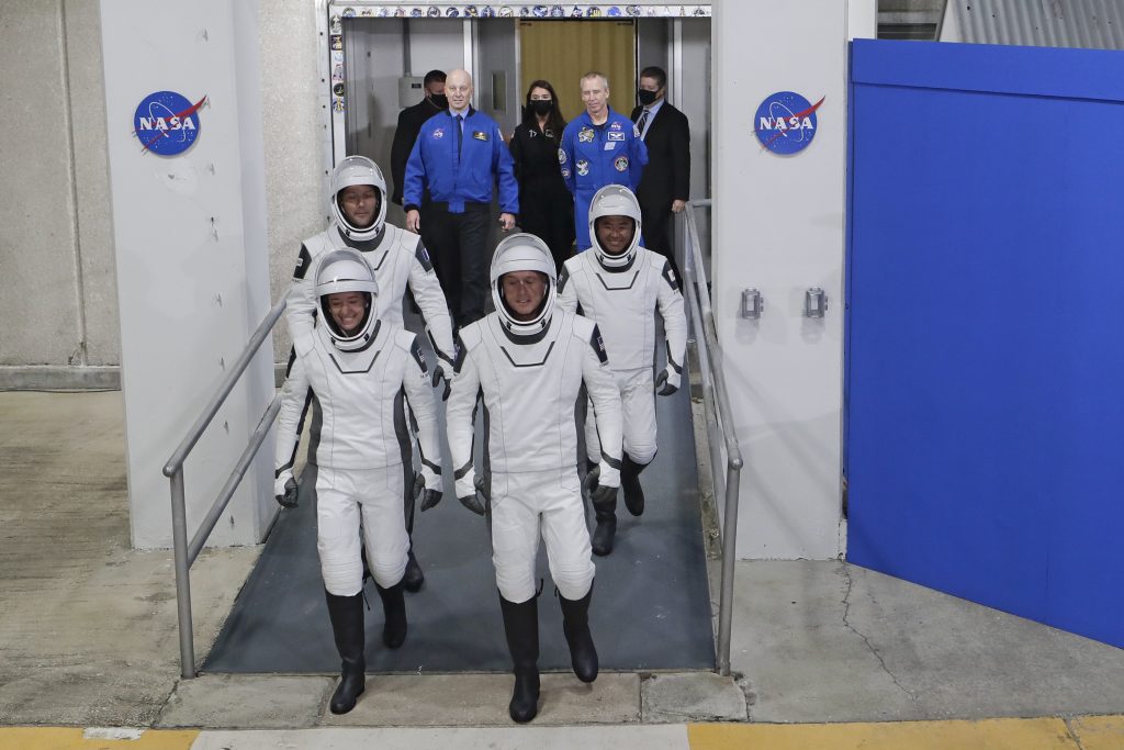 カプセル型宇宙船クルードラゴンの宇宙飛行士ら。前列の左より、NASAの宇宙飛行士であるミーガン・マッカーサーさん、同じくNASAの宇宙飛行士であるシェーン・キンブローさん、後列、欧州宇宙機関の宇宙飛行士であるトマス・ペスケさんと、JAXAの宇宙飛行士である星出彰彦さん。フロリダ州ケープ・カナベラルのケネディ宇宙センターにて、オペレーションズ&チェックアウト棟を出て、国際宇宙ステーションへ向かう任務のためにカプセル型宇宙船へと乗り込む様子。2021年4月23日撮影。（資料写真/AP通信）