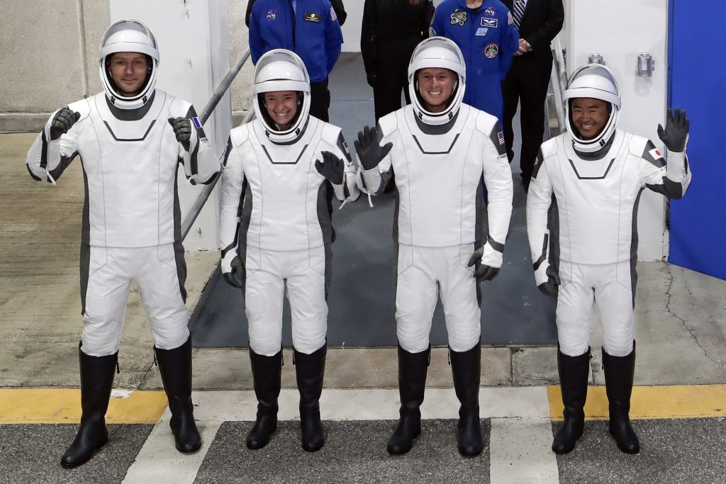 カプセル型宇宙船クルードラゴンの宇宙飛行士たち。前列の左より、欧州宇宙機関の宇宙飛行士であるトマス・ペスケさん、NASAの宇宙飛行士であるミーガン・マッカーサーさん、同じくNASAの宇宙飛行士であるシェーン・キンブローさん、および、JAXAの宇宙飛行士である星出彰彦さん。フロリダ州ケープ・カナベラルのケネディ宇宙センターにて、オペレーションズ&チェックアウト棟を出て、国際宇宙ステーションへ向かう任務のためにカプセル型宇宙船へと乗り込む様子。2021年4月23日撮影。(資料写真/AP通信)