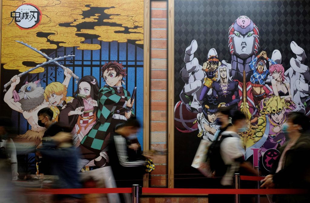 この写真では、2021年2月4日第9回台北コミック・アニメフェスティバル開催中、日本の漫画「鬼滅の刃」のポスターの前で人々が立ち並んでいる。(AFP)