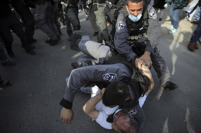 金曜にエルサレムで行われた立ち退き計画に対する抗議運動中、イスラエルのクネセトにおけるアラブ政党の同盟組織ジョイントリスト唯一のユダヤ人メンバーであるオファー・カシフ議員ともみ合う警察。（AP）