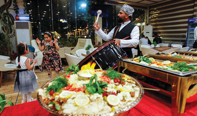 イラクのナジャフにあるレストランにて、イスラム教徒の断食開始前、夜明け前の食事（スフール）中に太鼓を叩く男性。 （ロイター）