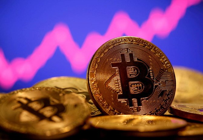 価格チャートの前にある仮想通貨ビットコインのイメージ (ロイター)