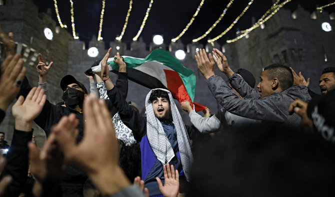 エルサレムの旧市街、ダマスカス門の外で国旗をなびかせるパレスチナ人抗議者、2021 年 4 月 26 日。(AFP)