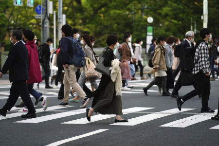 2021年4月19日(月)、東京の横断歩道を歩くコロナウイルスの広がりを抑制するために保護マスクを着用した人々。日本の首都は月曜日に400件以上の新しい症例を確認した。(AP)