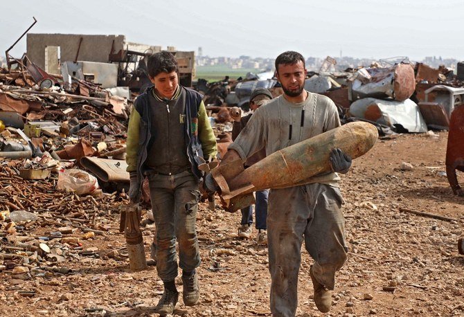 北西のイドリブ県にあるマアラ・ミラン市のはずれに位置する金属廃棄場で働くシリアの男性が、無力化した航空爆弾を運ぶ。2021年3月10日。（ファイル/AFP）