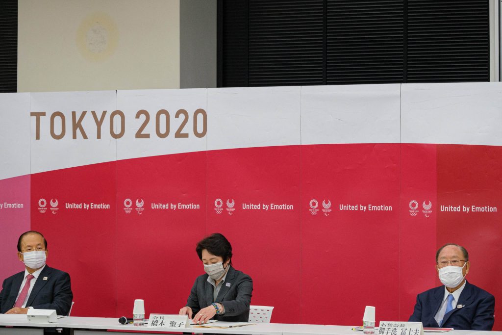 2021年5月26日に東京で行われた2020年東京オリンピック・パラリンピック組織委員会理事会に出席した、東京オリンピック組織委員会事務総長の武藤敏郎氏（左）、2020年東京オリンピック・パラリンピック競技大会組織委員会会長の橋本聖子氏（中央）、キヤノン最高経営責任者兼名誉会長の御手洗冨士夫氏（右）。(AFP)