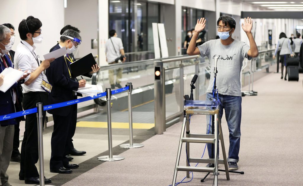 ミャンマーで拘留されていた日本人ジャーナリストの北角裕樹さんが成田空港でメディアの取材に応じる様子、成田市。(AFP)