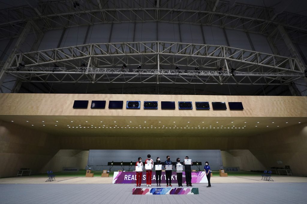 東京の朝霞射撃場で2021年5月18日火曜に開かれた東京2020オリンピック射撃競技テストイベントの表彰式に参加する、10mエアピストル混合団体競技の地元選手たち。（AP写真/ユージン・ホシコ）