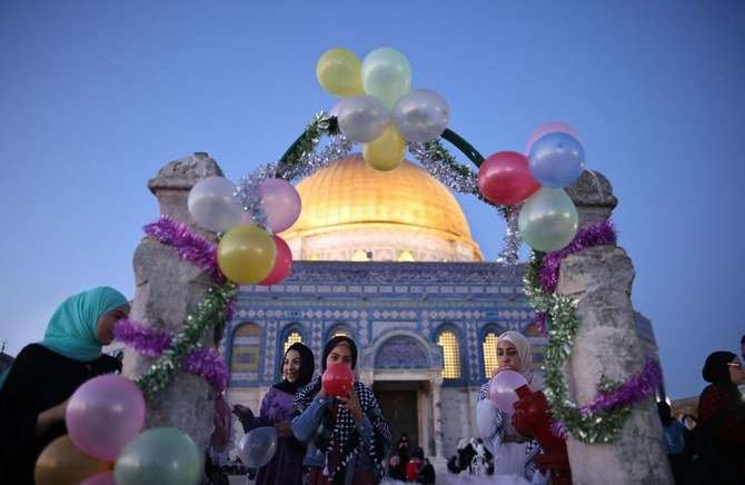 アル・アクサ・モスクでの礼拝後、イード・アル・フィトルの祝日を祝う礼拝者たちの中で、風船を膨らませるイスラム教徒の女性たち（AFP通信）