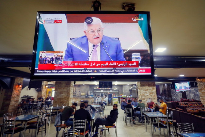 来たるべき選挙について話し合う会議でのパレスチナのマフムード・アッバス議長の演説の生放送を映すスクリーンが、ラマラのコーヒーショップで見られる。（ロイター）