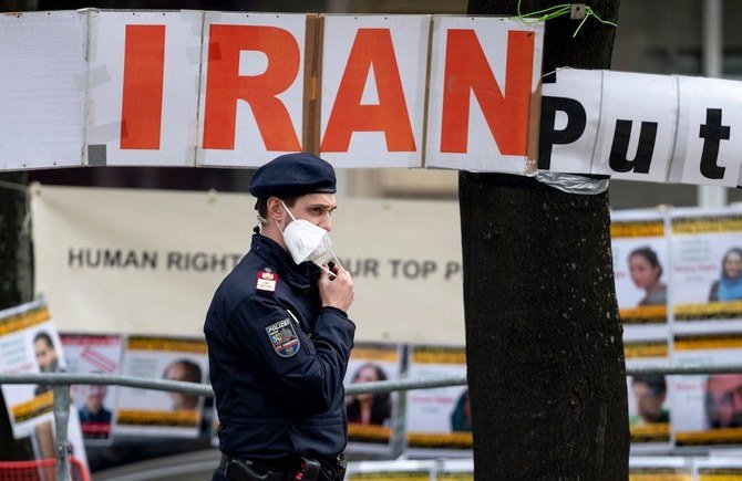 グランドホテルウィーンの前で、イランの野党グループであるイラン抵抗国民会議のメンバーが掲げた横断幕の前で、警察官がパトロールする。(AFP通信)