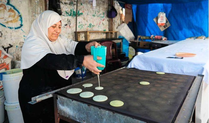 コロナ禍にある2020年4月27日にガザ地区中心街ディールアルバラで、聖なる断食月のラマダン期間に、パレスチナ人のイヤード・サルハさんが、販売する伝統的なデザートのカタイフを作っている。（AFP）