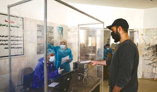 ガザ地区の男性が、ワクチン接種の受付け手続きをしている。英国の変異種の発生により、パレスチナの若い人々の間で新型コロナウイルス感染症が急増している。