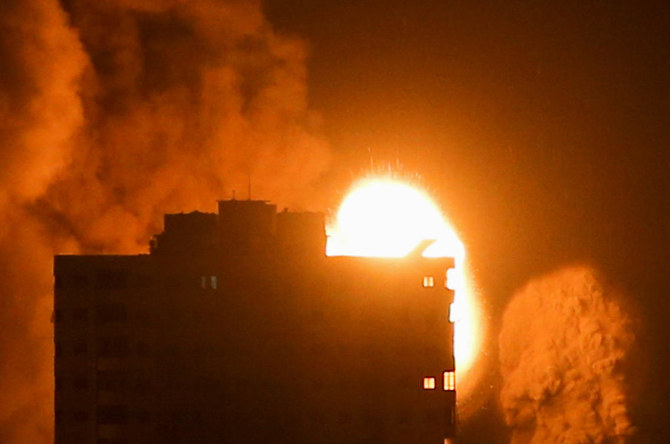2021年5月17日、明け方のガザシティーで、イスラエルの空爆の間、あるビルの上に煙と炎が立ち上る。（ロイター通信／イブラヒーム・アブ・ムスタファ）
