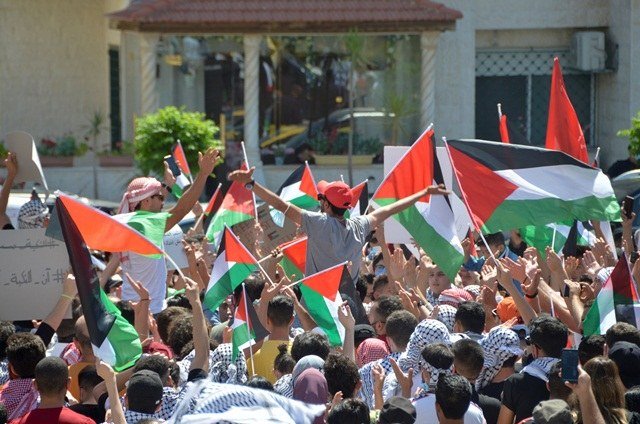 イスラエル大使館付近にてアンマンのパレスチナの人々との団結を表明するデモ参加者。大使は月曜、90人のヨルダン議員によって追放の要求を受けている。(ロイター)