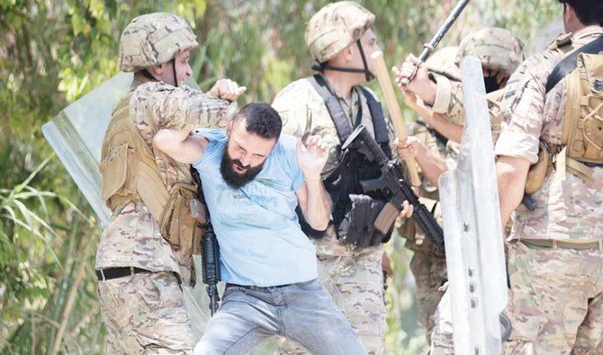 憤ったレバノン人の男たちともみ合う兵士たち。男たちはシリア大統領選挙に投票するシリア人を乗せてベイルート近郊の大使館に向かっていたバスを襲撃していた。(資料/AP通信)
