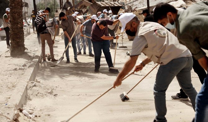 イスラエルとハマスの間で11日間続いた戦闘が停戦によって終結してから1週間以上が経過した2021年5月29日、ガザ市ではパレスチナ人のボランティアが瓦礫を取り除き、道路を清掃している。(AFP)