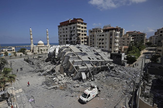 ガザ市では、イスラエル軍の空爆で海岸沿いの12階建てのビルが破壊されて、人々が瓦礫をかき分けていた。（AFP通信）