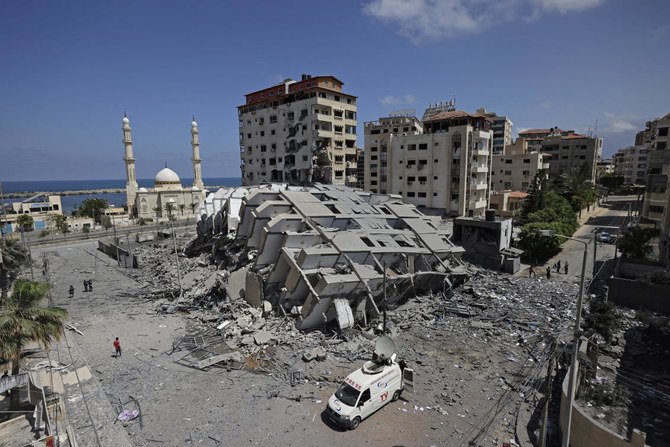 ガザ市では、イスラエル軍の空爆で海岸沿いの12階建てのビルが破壊されて、人々が瓦礫をかき分けていた。(AFP通信)