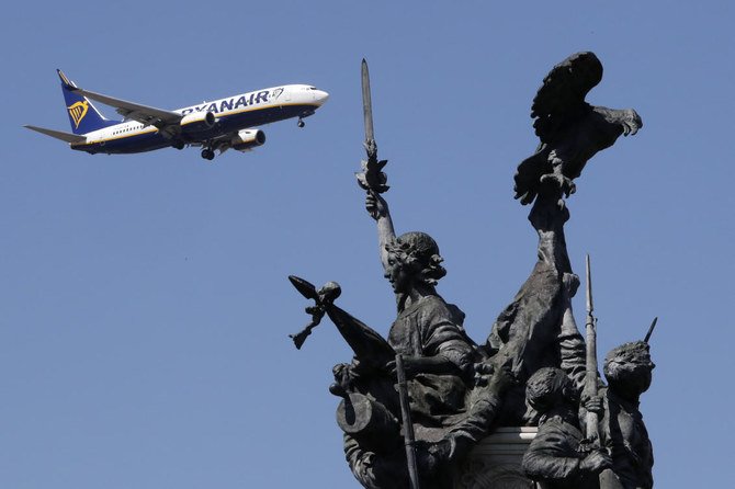 リスボン空港に着陸しようとするライアンエアーの航空機が、手前に見える「半島戦争の英雄たちの記念碑」の向こうを飛んでいる。（AP通信）