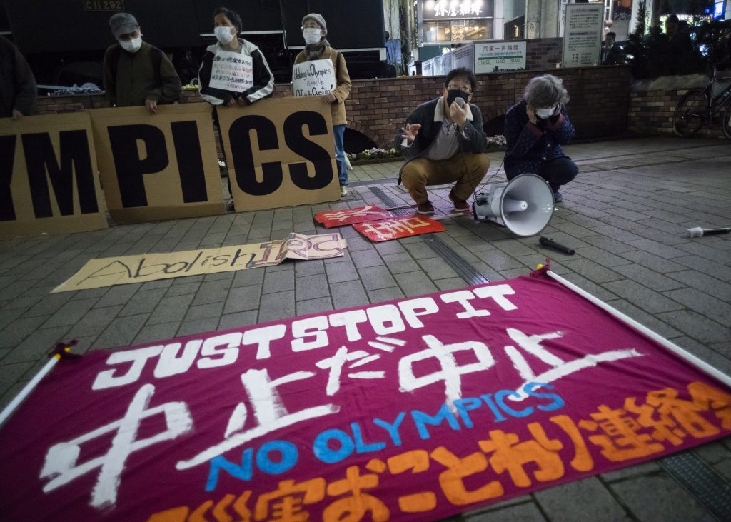 2021年3月25日の写真、2020年東京オリンピック・パラリンピック競技大会開催反対デモで東京の参加者が「オリンピック中止」の旗を置く。（AP）