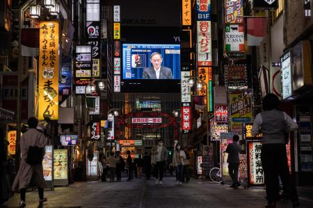 2021年5月7日、東京でコロナウイルス非常事態の延長を発表する記者会見で演説する菅義偉首相のスクリーン。(AFP)