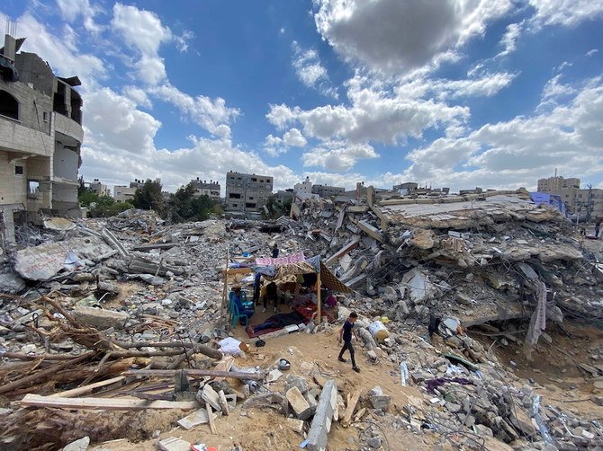 2021年5月23日、瓦礫になった家々の中、仮設テントのそばを歩くパレスチナのザワラ家の少年。自宅はガザで起きたイスラエルとパレスチナの戦闘中にイスラエルの空爆で破壊された。2021年5月23日撮影。（ロイター）