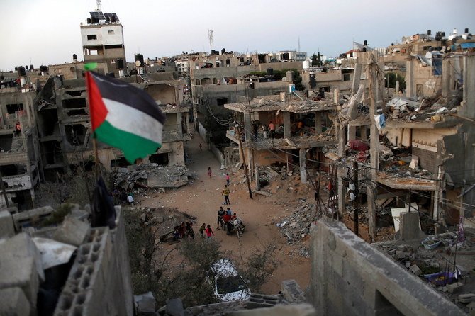 2021年5月25日、ガザ地区の廃墟の中ではためくパレスチナの旗。家々はイスラエルとパレスチナの戦闘中にイスラエルの空爆で破壊された。2021年5月25日撮影。（ロイター）
