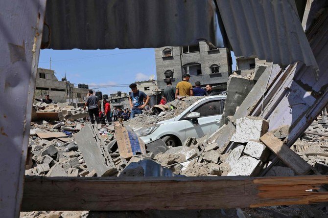 2021年5月20日、ガザ地区南部のラファで、イスラエルの空爆を受けた現場にパレスチナ人が集まる。（AFP）