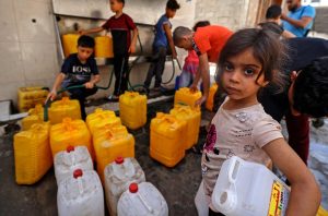 2021年5月20日、イスラエルの砲撃による死と破壊の中で、ガザ市でガロンに水を入れる子供たち。（AFP / MAHMUD HAMS） 
