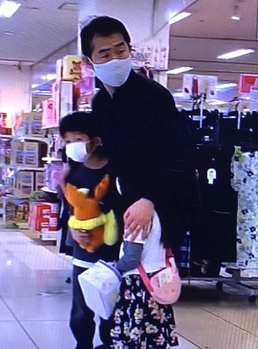 福島のショッピングモールで撮影された映像には、土曜日の午前中に起きた強い地震で揺れる陳列台や棚から子どもを守るために抱きかかえている男性が写っている。（NHK）