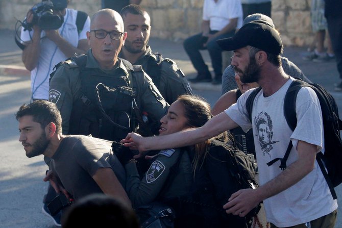 2021年5月14日、東エルサレムのシェイク・ジャラー地区で、パレスチナ人の数家族が強制立ち退きの危機に瀕し、その境遇に抗議する者と格闘するイスラエルの国境警備隊。（AP Photo/マフムード・イルレアン）