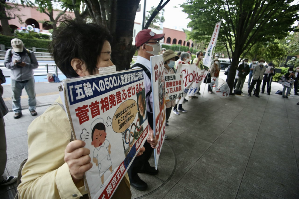 5月18日、五輪に反対するデモ隊が東京の日本オリンピック委員会（JOC）本部前でバナーを掲げた。そのうちの一つは子供たちの大会への強制参加を止めるよう要求した。