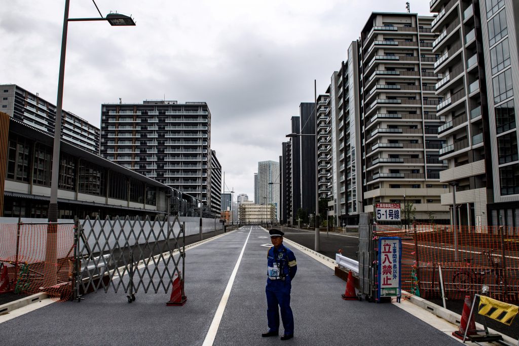 東京のオリンピック選手村の外に立っている警備員。(AFP)